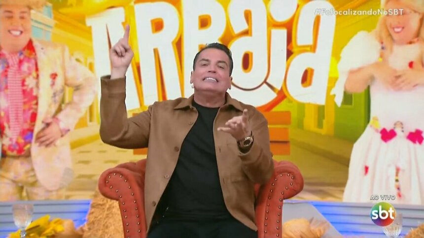 Leo Dias levanta o dedo para cima enquanto apresenta o Fofocalizando no SBT