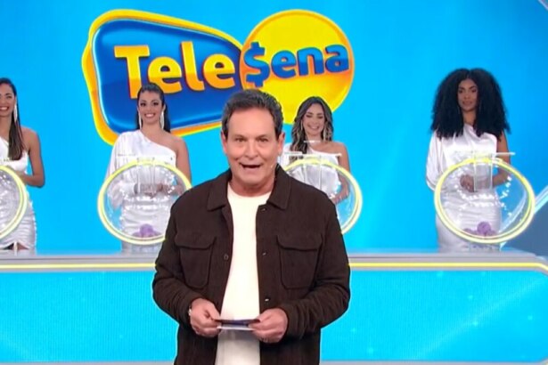 Luis Ricardo caminha no cenário do sorteio da edição 56 da Tele Sena Semanal. O cenário está com artes gráficas azul