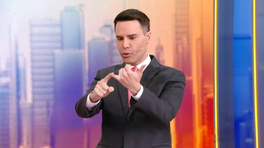 Luiz Bacci conta números nos dedos no cenário do Alô Você