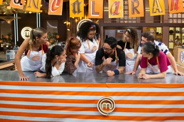 Participantes reunidos em cima da bancada em trecho da Prova dos Pasteis no MasterChef
