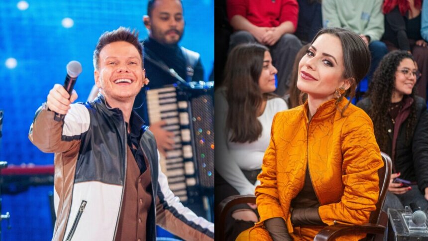 Michel Teló segura microfone no palco do Altas Horas. Ao lado Sandy sentada no palco do mesmo programa. Ela veste uma roupa laranja