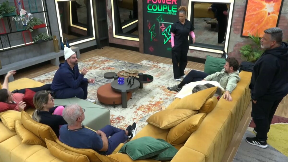 Silvia com a roupa da Prova das Mulheres conta para os aliados como foi a disputa. ela está em pé no centro da sala do Power Couple