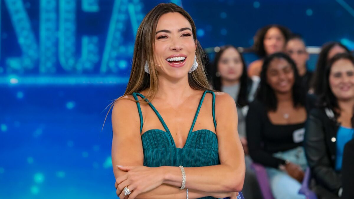 Patricia Abravanel sorridente no cenário do Programa Silvio Santos