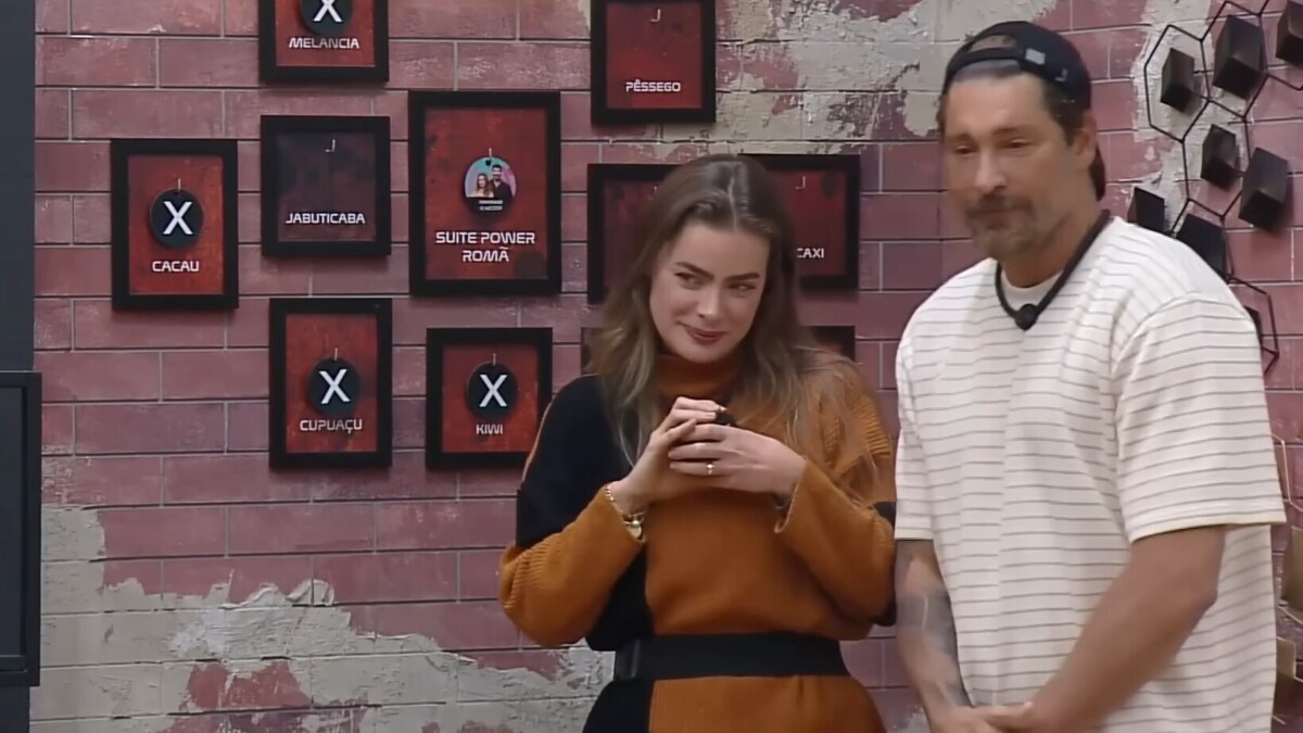 Rayanne e Victor em frente ao quadro da divisão de quartos no Power Couple Brasil 7