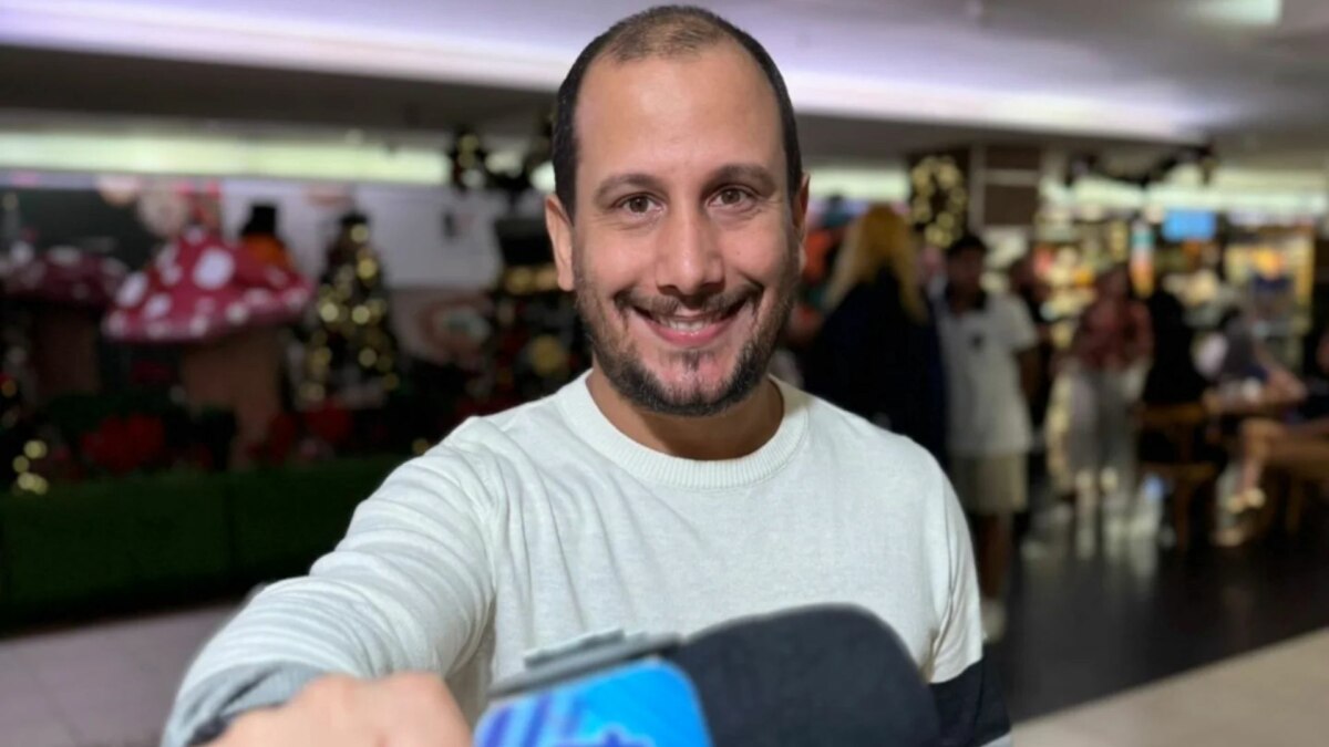 Repórter Rodrigo Assis em foto posada com o microfone do Fofocalizando