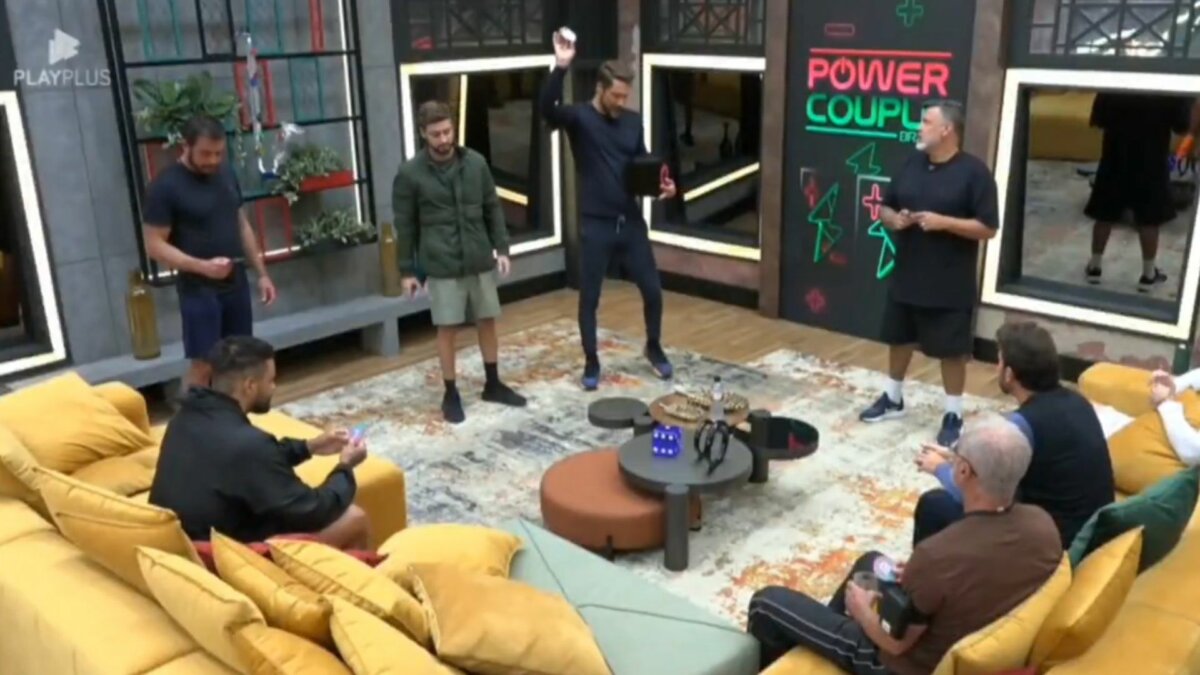 Homens do Power Couple em pé na sala da Mansão realizando o sorteio da 7ª Prova dos Homens