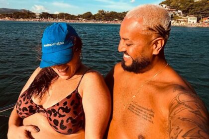 Tati Machado e marido o em trecho de foto na gravidez, em passeio na praia