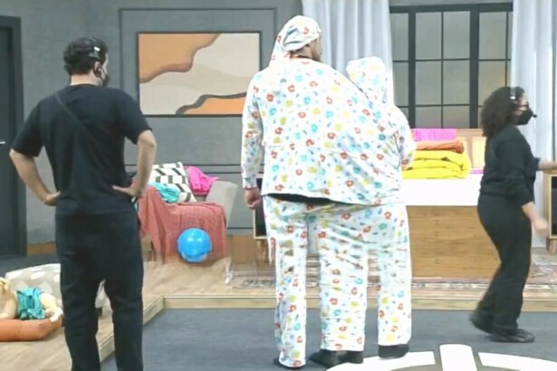 Victor e Rayanne vestidos por um mesmo pijama caminham no cenário da Prova dos Casais do Power Couple Brasil 7