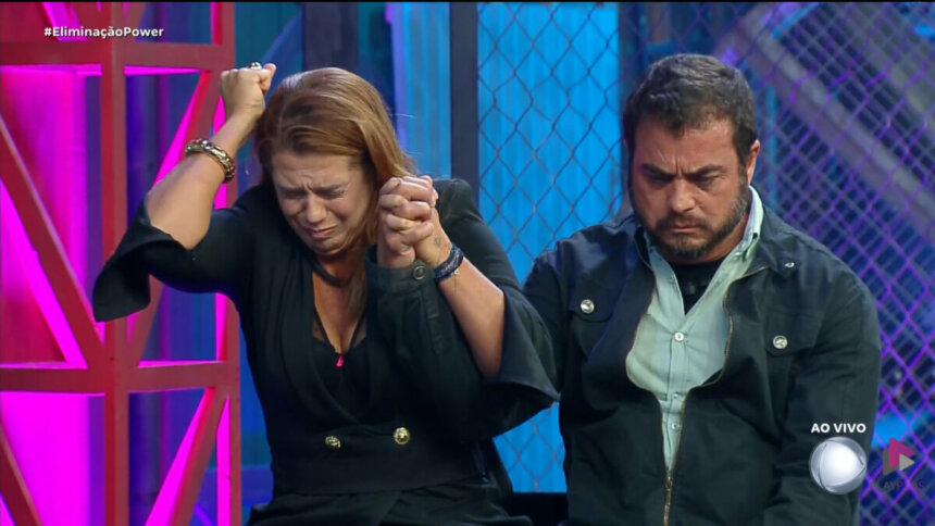 Adriana e Dhomini olhando para baixo assustados no cenário do Power Couple Brasil 7