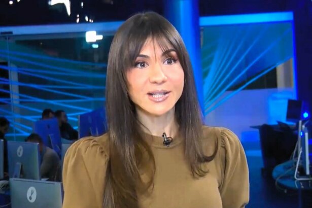 Amanda Klein em pé no meio da redação do RedeTV! News