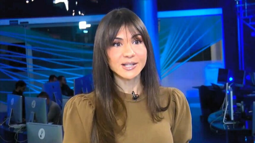 Amanda Klein em pé no meio da redação do RedeTV! News
