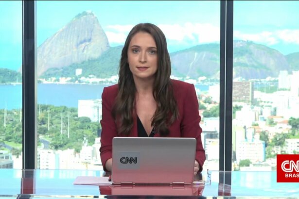 Amábyle Sandri sentada na bancada da CNN Brasil na sucursal do Rio de Janeiro