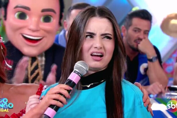 Mulher, vestindo a camisa do time azul, faz cara feia para Celso Portiolli após errar pergunta simples no Domingo Legal