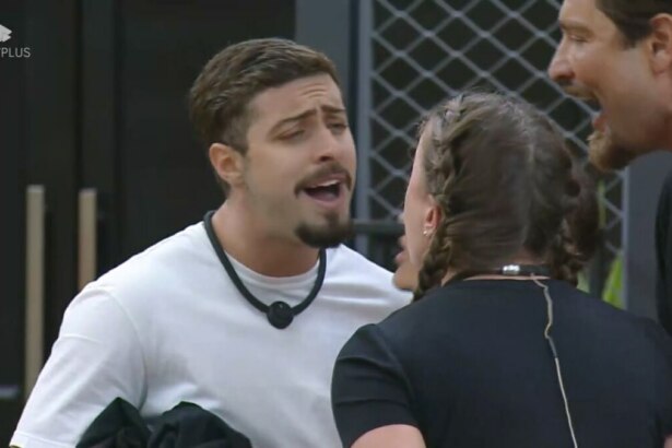 Eike sorrindo debochado cara a cara com Rayanne na sala mansão do Power Couple Brasil 7. Victor e Nat tentam apartar a briga