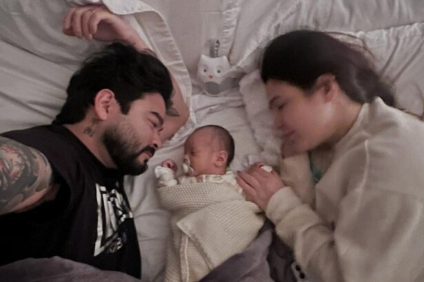 Davi Yudi deitado ao lado de Yudi e sua esposa