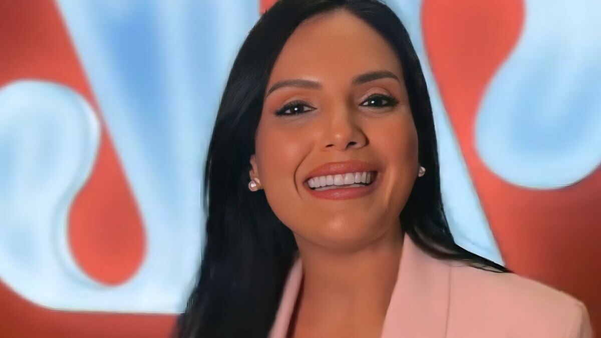 Márcia Dantas sorrindo em frente ao logo da Jovem Pan