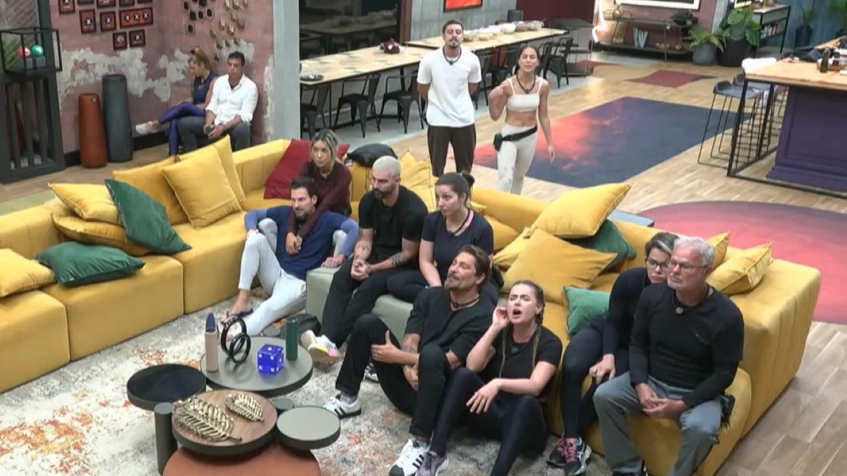 Casais sentados no sofá da mansão do Power Couple Brasil 7 ouvindo o resultado da nona Prova das Mulheres