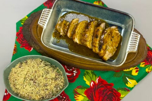 Picanha suína ao molho de laranja com farofa de couve com bacon em cima da mesa do É de Casa