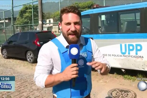 Rael Policarpo segura microfone da RECORD em uma rua do Rio de Janeiro ao lado onde acontece um acidente com duas motos