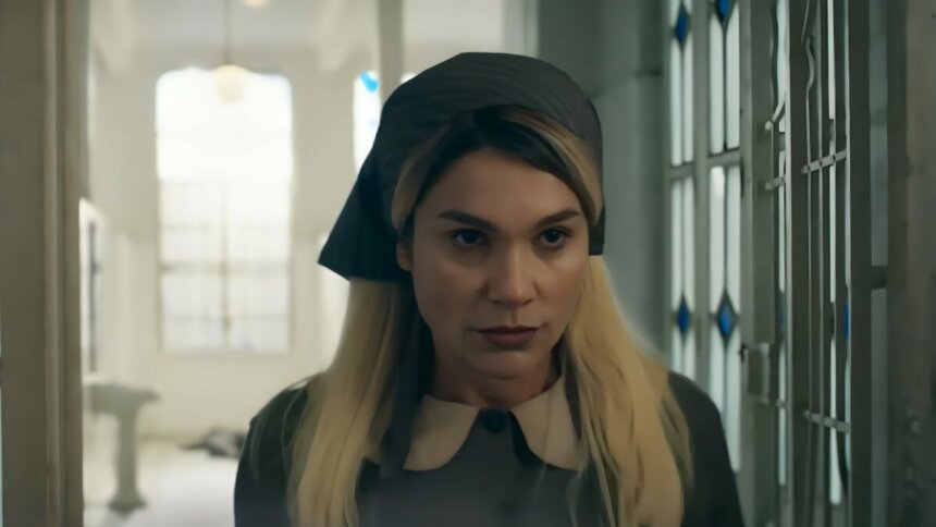 FLávia Alessandra, caracterizada como Sandra, com olhar maquiavélico em um corredor de hospital. A cena é da novela Êta Mundo Melhor!