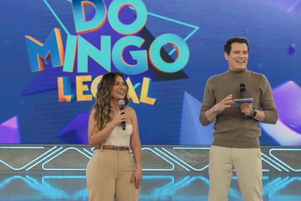 Simone Mendes ao lado de Celso Portiolli no palco do Domingo Legal. Os dois estão sorrindo