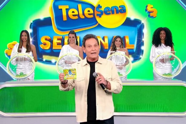 Luis Ricardo caminha no cenário do sorteio da edição 56 da Tele Sena Semanal. O cenário está com artes gráficas verde, cor do bilhete