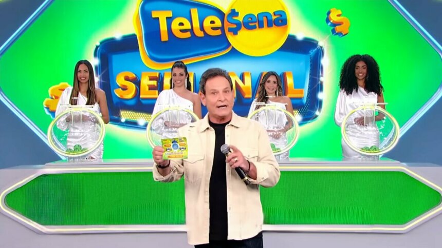 Luis Ricardo caminha no cenário do sorteio da edição 56 da Tele Sena Semanal. O cenário está com artes gráficas verde, cor do bilhete