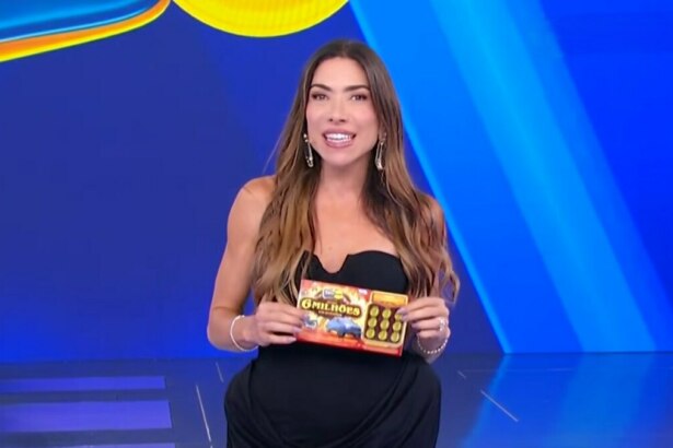 Patricia Abravanel no centro do cenário da Tele Sena de São João 2025. Cenário azul. ela segura o bilhete da edição no último sorteio