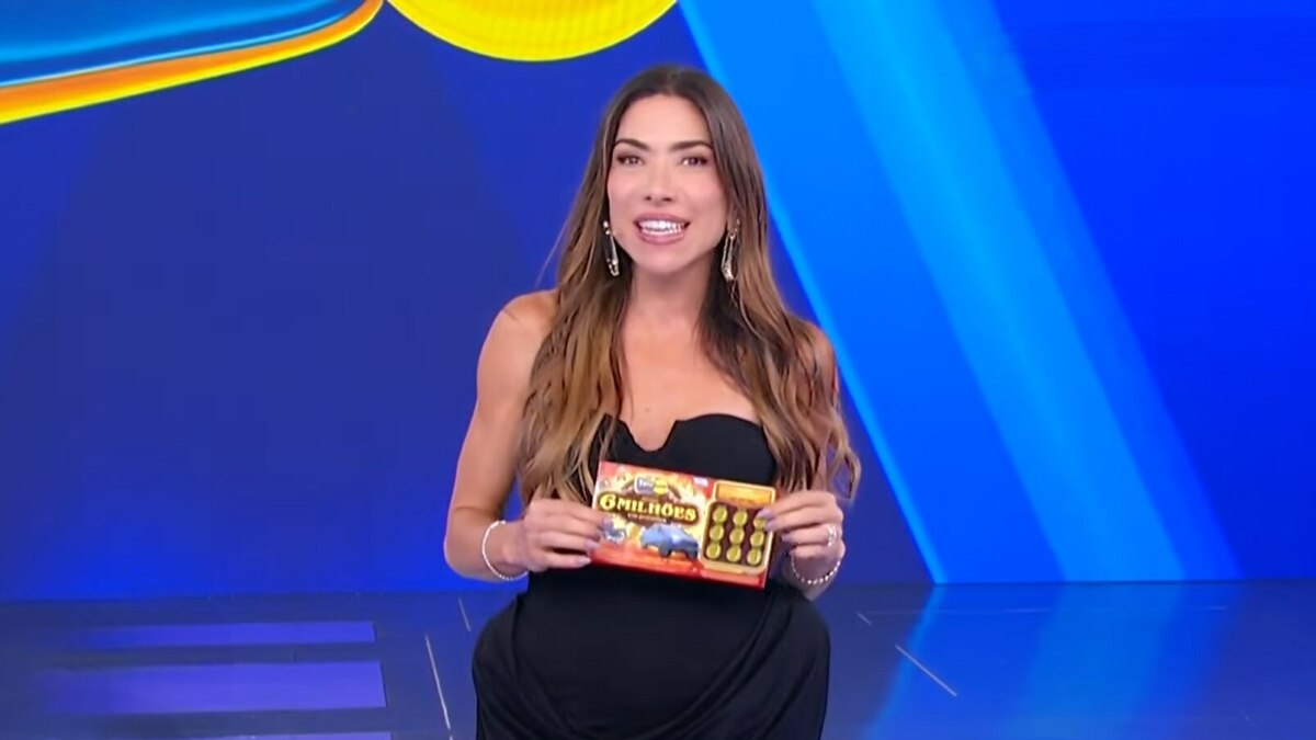 Patricia Abravanel no centro do cenário da Tele Sena de São João 2025. Cenário azul. ela segura o bilhete da edição no último sorteio