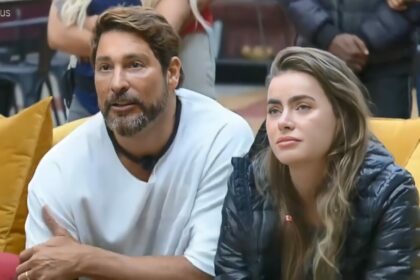 Victor e Rayanne sentados no sofá da sala da Mansão Power