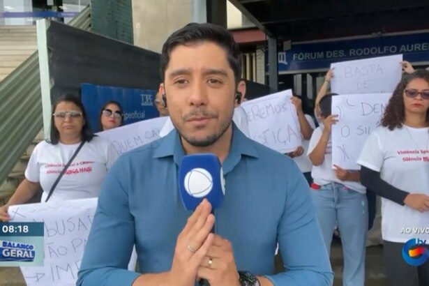 Anderson Souza segura o microfone da RECORD e faz sinal de gratidão com as mãos ao se despedir da TV Guararapes. Ele veste camisa de botão azul e e está emocionado