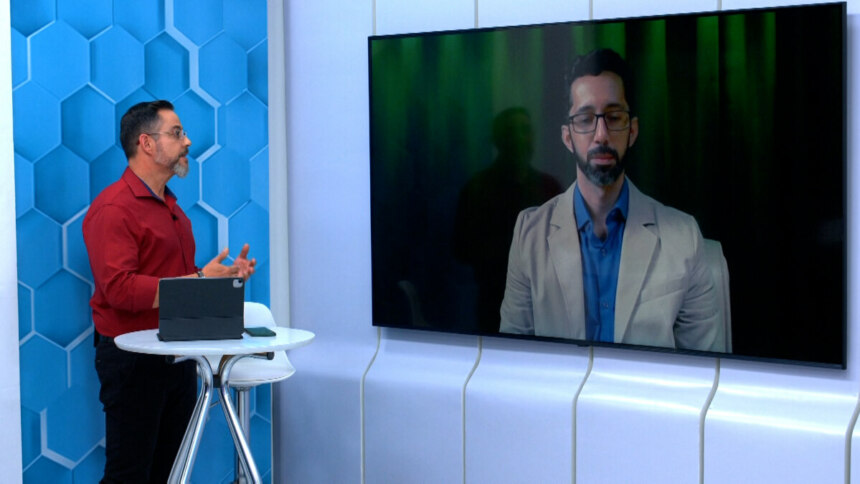 Eduardo Miranda conversa com um especialista no telão do cenário do Aparecida Debate
