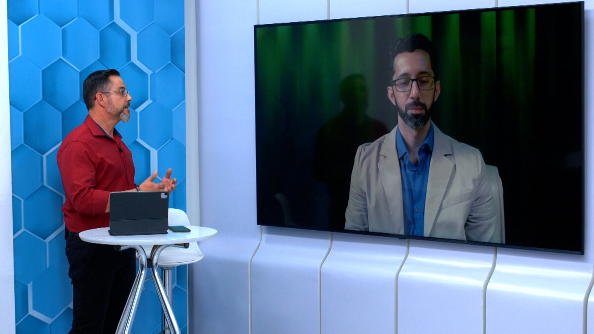 Eduardo Miranda conversa com um especialista no telão do cenário do Aparecida Debate