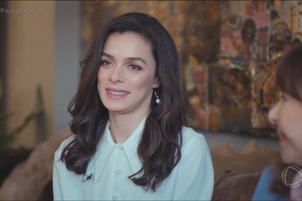Bahar com roupas finas e sorridente. Ela está sentada em um sofá em cena dos últimos capítulos da novela Força de Mulher