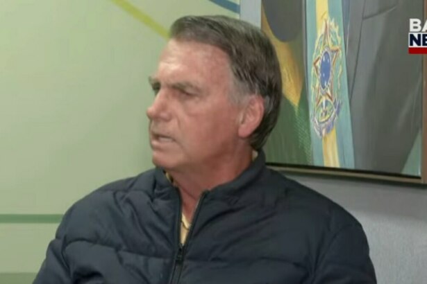 Bolsonaro, vestindo uma jaqueta preta, em tom sério, na entrevista a BandNews TV