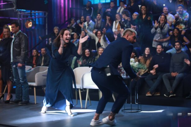 Carol batendo palmas e Radamés correndo de alegria no palco da final do Power Couple Brasil 7