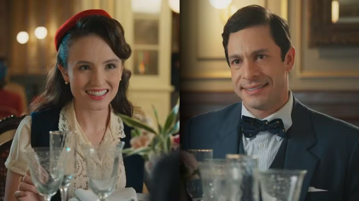 Estela (Larissa Manoela) frente a frente com Celso (Rainer Cadete) em um restaurante. Ela sorrir disfarçadamente. Ele sorrir normal em cena de Êta Mundo Melhor!