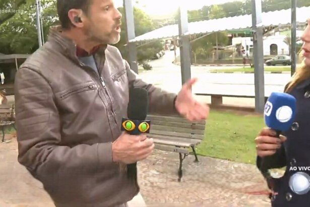 Lucas Martins com o microfone da Band nas mãos gritando com a repórter Grace Abdou que segura o microfone da RECORD