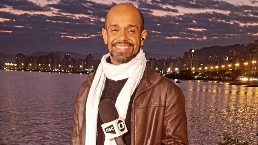Cristiano Gomes, sorridente e com foto posada com o microfone da NSC TV, afiliada da Globo