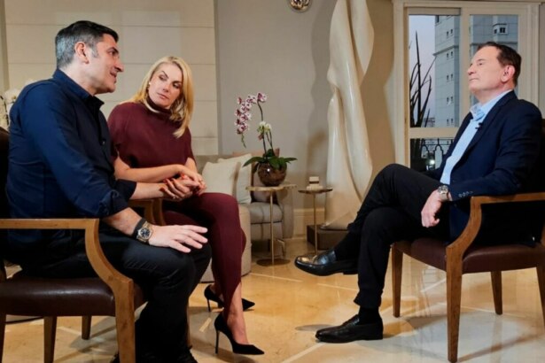 Edu Guedes, Ana Hickmann e Roberto Cabrini, sentados frente a frente, em trecho de entrevista ao Domingo Espetacular