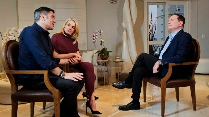 Edu Guedes, Ana Hickmann e Roberto Cabrini, sentados frente a frente, em trecho de entrevista ao Domingo Espetacular