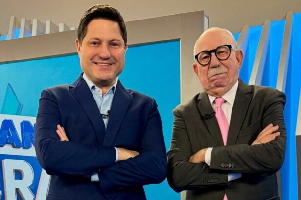 Eleandro Passaia e Renato Lombardi, de braços cruzados e sorridente, no cenário do Balanço Geral