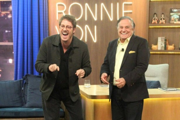 Fábio Porchat e Ronnie Von, sorridentes em frente a bancada, em trecho do Companhia Certa especial de aniversário