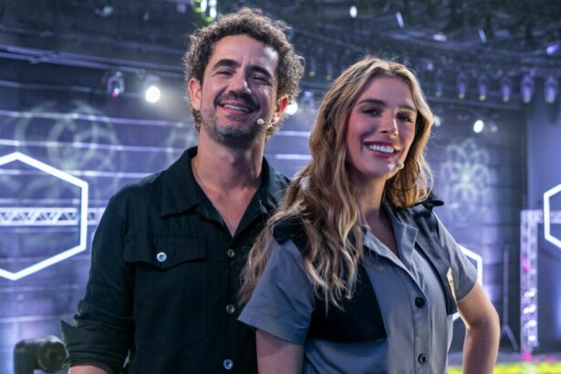 Felipe Andreoli e Rafa Brites sorrindo, em foto posada no cenário do Game dos 100