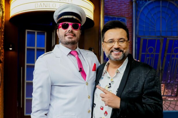 Geraldo Luís e Danilo Gentili sorridentes, em foto posada no cenário do The Noite