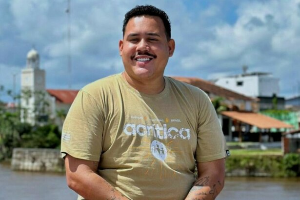Lucas Buda sorridente, em foto posada em frente ao Rio Amazonas