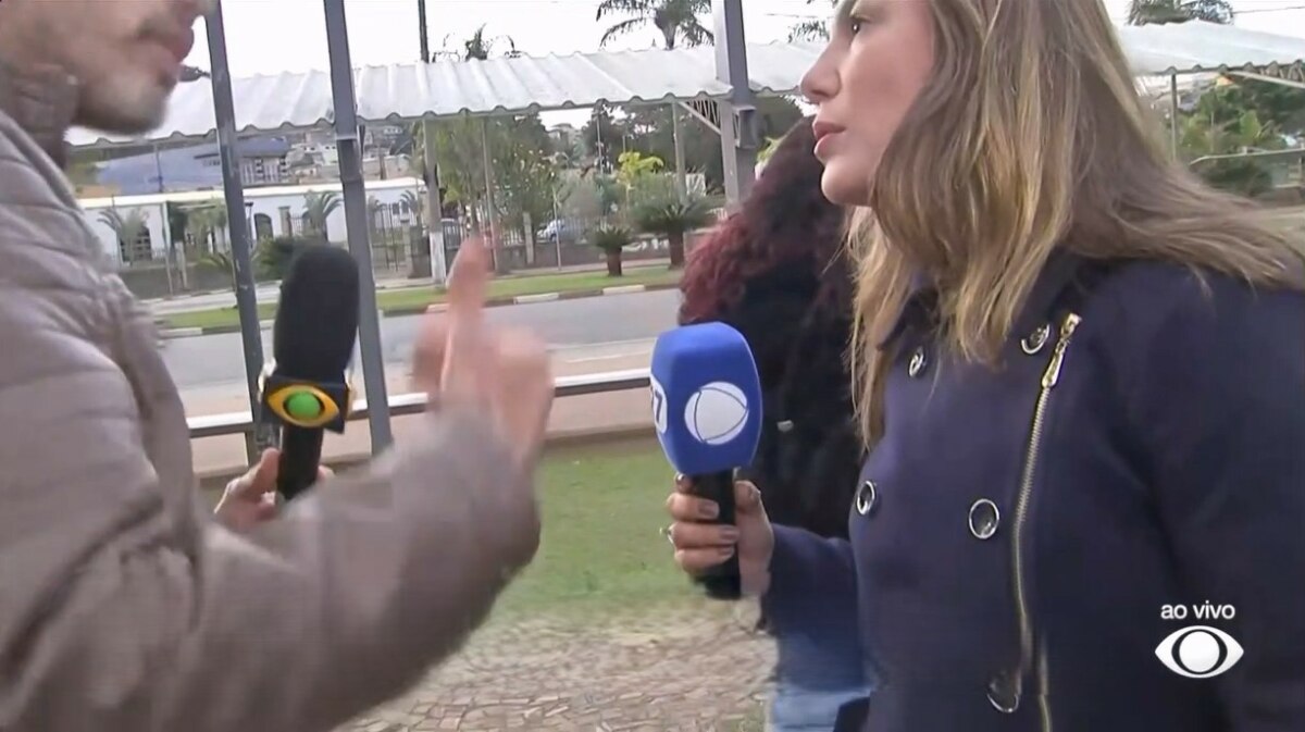 Lucas Martins da Band gesticula na frente da repórter Grace Abdou da RECORD