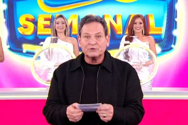 Luis Ricardo segura o bilhete rosa da Tele Sena Semanal edição 60 na frente dos globos e das assistentes de palco