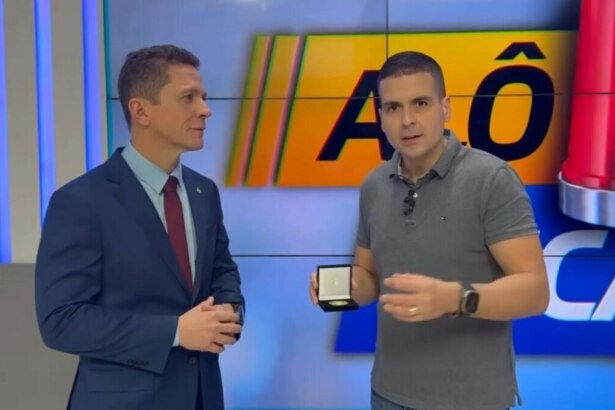 Marcelo Castro, ao lado do delegado da polícia, após receber presente no estúdio do Alô Juca