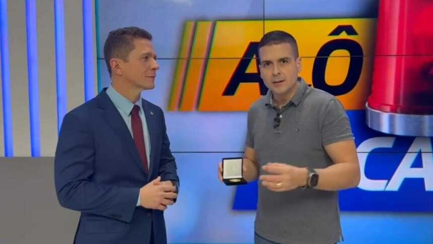 Marcelo Castro, ao lado do delegado da polícia, após receber presente no estúdio do Alô Juca